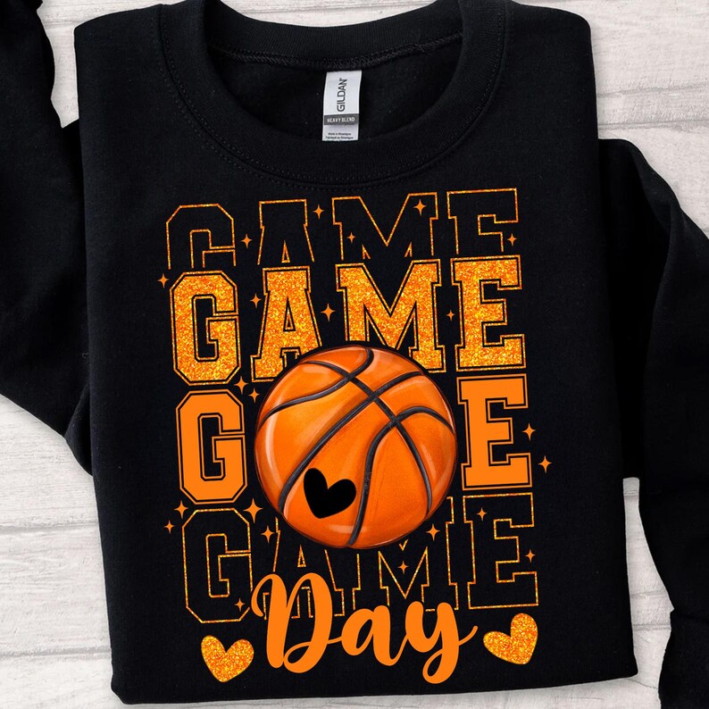 Peut inclure: Sweat-shirt noir avec un texte en paillettes orange qui dit "Game Game Go Game Day" avec un graphique de ballon de basket au centre.