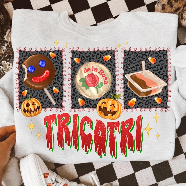 K&ouml;nnte beinhalten: Ein hellgraues Sweatshirt mit einem Halloween-Motiv. Das Design umfasst einen Lolli, eine S&uuml;&szlig;igkeit und ein Dessert, jeweils umrahmt von einem Leopardenmuster. Das Wort "TRICOTRI" ist in Rot und Gr&uuml;n gedruckt.