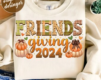 May include: A white sweatshirt with the text "FRIENDSgiving 2024" in colorful patchwork letters. The letters are decorated with hearts, stars, and a leopard print. The design also includes three pumpkins with bows.