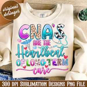 May include: A sublimation design featuring a light beige sweatshirt with a colorful graphic that reads "CNA's are the heartbeat of long term care". The graphic includes a stethoscope, a syringe, a caduceus, and hearts.