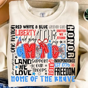 May include: A white sweatshirt with a red, white, and blue graphic design featuring the words "One Nation", "Liberty", "4th of July", "America", "Land Support", "We Love", "Our Troops", "Pride", "Independence", "Est 1776", "Freedom", and "Home of the Brave".