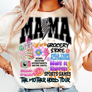 May include: A white t-shirt with a black graphic that says "MAMA" with a lightning bolt and checkered pattern. The graphic also includes images of a peace sign, a donut, a camera, a lightning bolt, a smiley face, a glass of iced coffee, and the text "Work Grocery Store, School Vacation Appointments Doctor Visits, Field Trips Playground, Make it Happen, Kitchen Practice, Sports Games, The Mother Hood Tour."