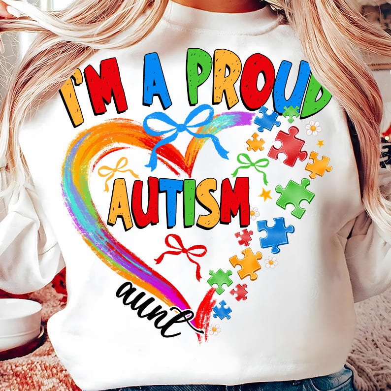 May include: White sweatshirt with a rainbow heart and the text "I'm a proud autism aunt". The heart is surrounded by puzzle pieces and bows.