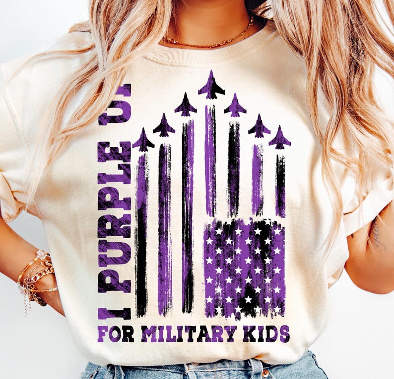 May include: A white t-shirt with a purple and black American flag design. The flag has a distressed look and features purple stars and stripes. The text "I Purple You For Military Kids" is printed on the shirt.