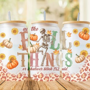 May include: A set of three glass tumblers with bamboo lids and metal straws. The tumblers feature a fall-themed design with pumpkins, sunflowers, and a skeleton. Text on the tumblers reads "at the fall things or whatever blink 182 said."