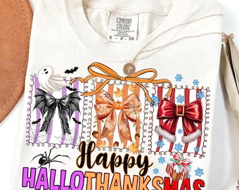 Puede incluir: Camiseta color crema con un diseño gráfico que presenta tres lazos decorativos: un lazo negro con alas de murciélago, un lazo con temática otoñal y un lazo navideño rojo. El texto "Happy Hallothanksmas" está debajo.