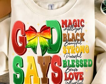 May include: A white sweatshirt with the words "God Says" in colorful letters. The letters are decorated with a red, yellow, and green bow. The words "Magic, Intelligent, Black, Beautiful, Strong, Powerful, Blessed, Brave, Love, Influential" are written in black text on a white background.
