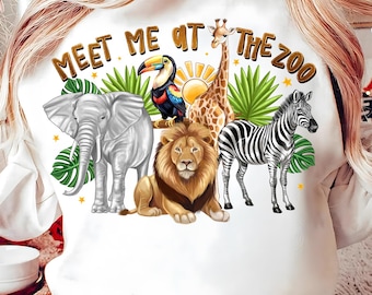 May include: White sweatshirt with a graphic print of a lion, zebra, elephant, giraffe, and toucan. The text "Meet Me At The Zoo" is printed on the sweatshirt.