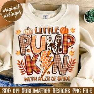 May include: A white sweatshirt with a graphic design that says "Little Pumpkin with a lot of spice". The graphic is made up of different patterned squares and includes a pumpkin, leaves, and a lightning bolt.