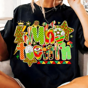 May include: Black t-shirt with a colorful "June Tenth" graphic. The design features a crown, stars, and various patterns in red, green, yellow, and black. The text is in a bold, multi-textured style.