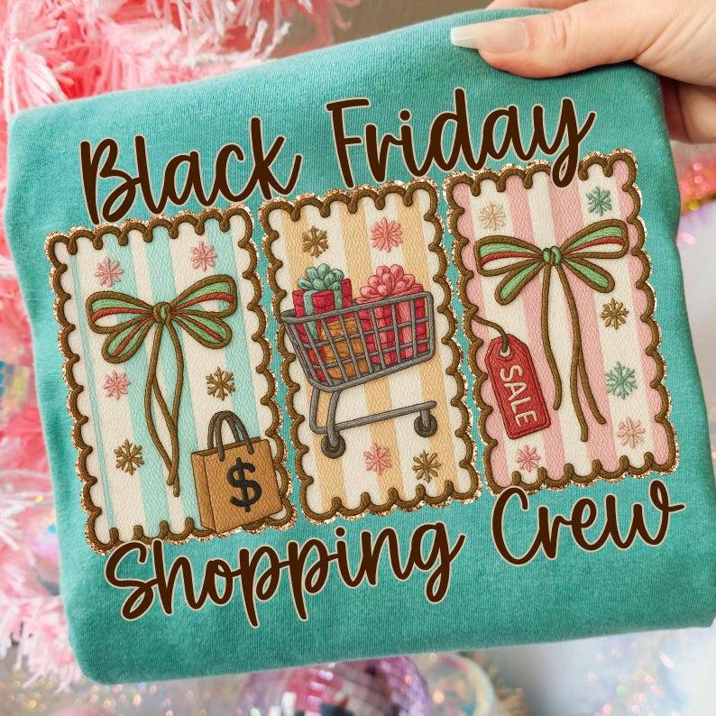 May include: Teal t-shirt with the words "Black Friday Shopping Crew" in brown script. The shirt features three decorative panels with bows, a shopping cart, a shopping bag, and a sale tag.