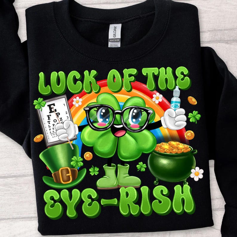 May include: Black sweatshirt with a green four-leaf clover wearing glasses and a hat. The clover is holding a pot of gold and an eye chart. The text reads "Luck of the Eye-rish".