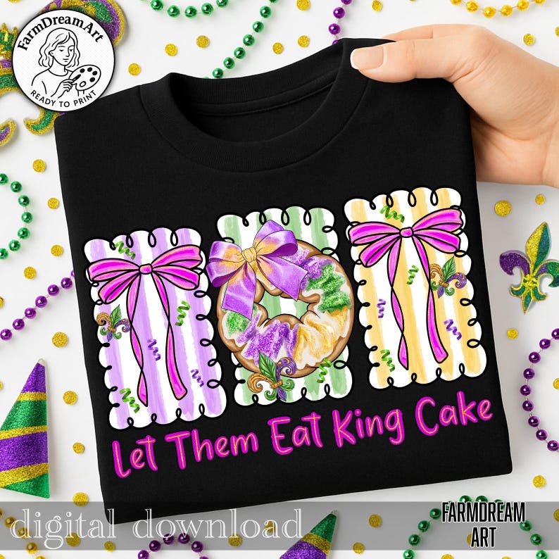 May include: Black t-shirt with a vibrant illustration of three King Cakes, each adorned with purple bows. The design incorporates purple, green, and yellow elements, and the text reads "Let Them Eat King Cake." Mardi Gras beads surround the design.