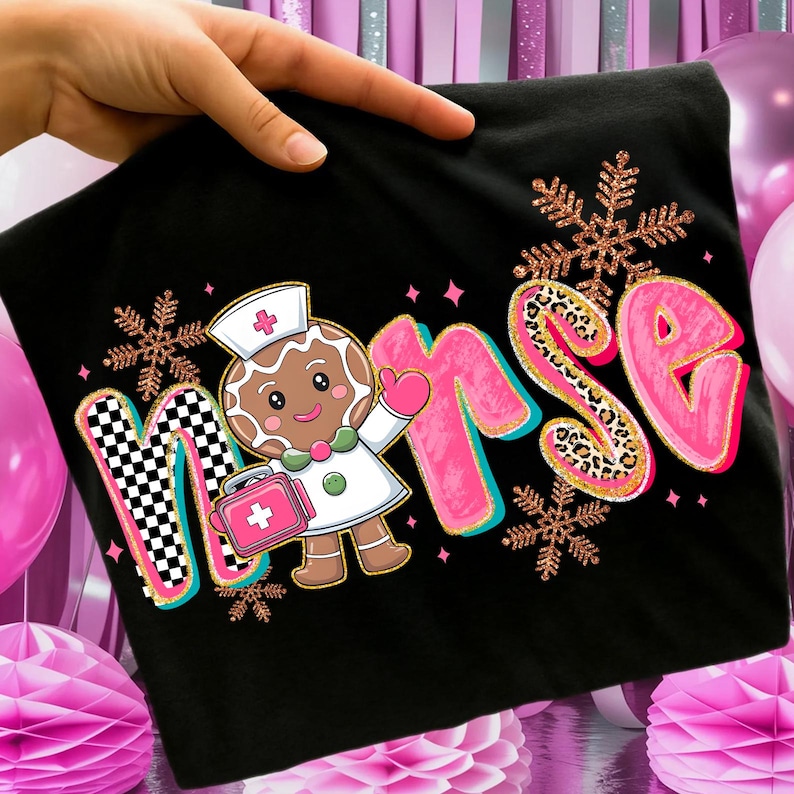 May include: Black t-shirt featuring the word "Nurse" with a gingerbread nurse graphic. The "N" has a checkered pattern, the "RSE" is pink with leopard print accents, and snowflakes are scattered around the design. The gingerbread nurse is holding a medical bag.
