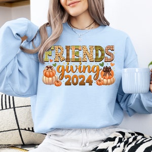 May include: Light blue sweatshirt with a graphic design of pumpkins and the text "FRIENDS giving 2024".