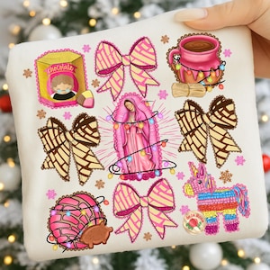 May include: A cream-colored graphic featuring illustrations of a box of chocolate, pink bows, a pink mug with hot chocolate, a depiction of the Virgin Mary, a concha, and a colorful piñata. The design includes string lights and decorative elements.