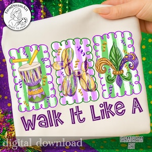 Puede incluir: Sudadera crema con un diseño morado y verde. El diseño incluye un tambor, un animal de globo y una flor de lis. El texto "Walk It Like A" está impreso en morado. También está impreso el texto "digital download".