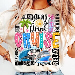 May include: A white t-shirt with a colorful graphic design that says "Drink Cruise" with images of a palm tree, a cruise ship, a dolphin, and a wave. The graphic also includes the words "Snorkeling", "Ocean", "Relax", "Islands", "Bingo", "Swim", "Show", and "Sight".