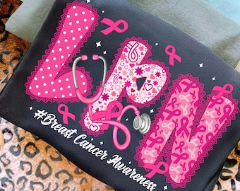 May include: Black t-shirt with the letters "LPN" in pink, decorated with polka dots, hearts, and ribbons. A pink stethoscope is featured in the design, along with the text "#Breast Cancer Awareness". The shirt is folded on a leopard print surface.