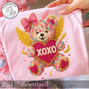 Könnte beinhalten: Rosafarbenes T-Shirt mit einem bunten Teddybär-Design, das ein Herz mit "XOXO" hält. Der Bär hat Flügel und eine Schleife. Die Wörter "digitaler Download" und "FarmDream Art" sind ebenfalls sichtbar.