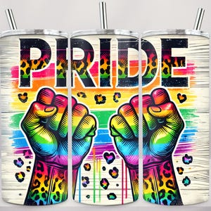 May include: A set of three stainless steel tumblers with the word "PRIDE" in large, bold letters. The design features a rainbow-colored fist, leopard print accents, and a rainbow background. The tumblers have silver straws.