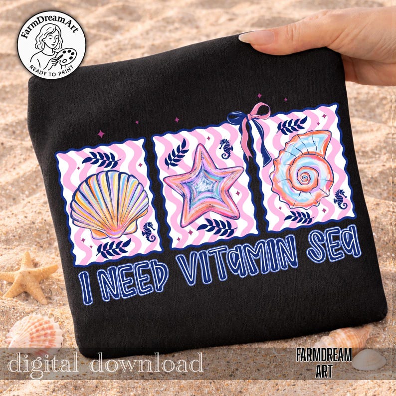 Pu&ograve; includere: Felpa nera con una grafica colorata di una conchiglia, una stella marina e una conchiglia a spirale, con la scritta "I NEED VITAMIN SEA". Il design include accenti rosa e blu, cavallucci marini e un fiocco.