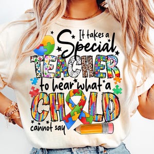 May include: White t-shirt with a colorful graphic that says "It takes a Special Teacher to hear what a Child cannot say". The graphic features a puzzle piece, a pencil, and a ribbon with puzzle pieces.