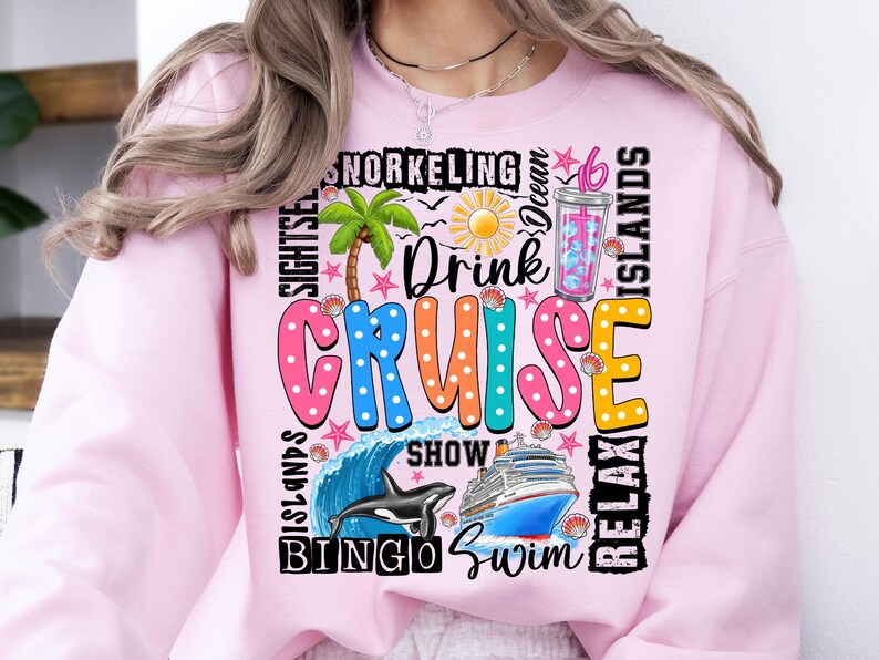 May include: Pink sweatshirt with a colorful graphic design that says "Drink Cruise" and includes images of a palm tree, a cruise ship, a whale, and a cocktail. The graphic also includes the words "Bingo", "Swim", "Show", "Relax", "Snorkeling", "Ocean", "Islands", and "Sights"