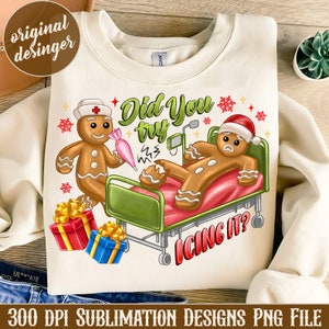 May include: Cream-colored sweatshirt featuring a humorous gingerbread design. The design includes gingerbread characters in a hospital setting with the text "Did You try Icing It?". The image also includes gift boxes and snowflakes.