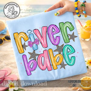 May include: Pale blue t-shirt featuring the words "River Babe" in vibrant bubble letters. The design incorporates a bow, stars, and the text "digital download" at the bottom. The FarmDreamArt logo is also visible.