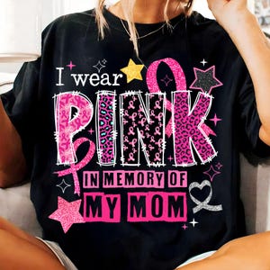 May include: Black t-shirt with the text "I wear PINK in memory of MY MOM". The word PINK is in a mix of leopard print and pink ribbon designs. The shirt also features stars and a ribbon.