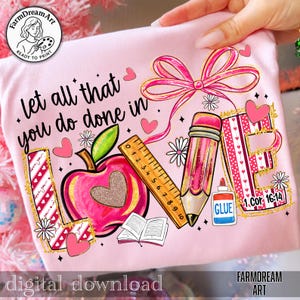May include: Pink t-shirt with a school-themed graphic. The design includes an apple, pencil, ruler, and the words "Let all that you do done in." Additional elements include hearts, flowers, and the text "1 Cor 16:14" and "GLUE".