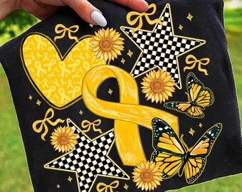 May include: Black square fabric featuring a yellow ribbon, heart, sunflowers, butterflies, and stars with a checkered pattern. The design includes bows and small diamond shapes. The fabric is held up by a hand.