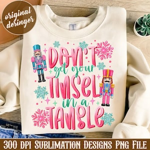 May include: A white sweatshirt with a pink and green design that says "Don't get your tinsel in a tangle". The design also features two nutcracker figures.