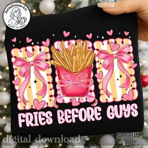 Op de afbeelding: Zwart grafisch T-shirt met een roze en geel ontwerp. Het ontwerp toont een roze bakje friet, roze strikken, hartjes en de tekst "FRIES BEFORE GUYS". De woorden "digital download" staan onderaan.