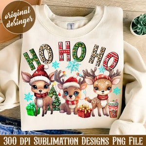 Peut inclure: Sweat-shirt crème avec un motif de Noël festif. Le motif présente les mots "HO HO HO" dans différents motifs, ainsi que trois cerfs de dessins animés portant des bonnets et des écharpes de Père Noël. Le texte "300 DPI SUBLIMATION DESIGNS PNG FILE" est en bas.