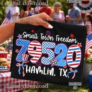 May include: A black t-shirt featuring the text Small Town Freedom and the number 79520 in red, white, and blue patterns. The design includes stars, a top hat, and the text HAMLIN, TX, with a checkered star accent and blue ribbon graphics.