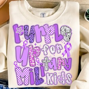 May include: Purple Up for Military Kids sweatshirt with a purple ribbon and a variety of purple patterns on the letters.