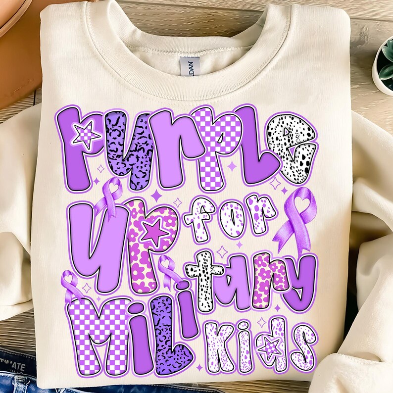 May include: Purple Up for Military Kids sweatshirt with a purple ribbon and a variety of purple patterns on the letters.