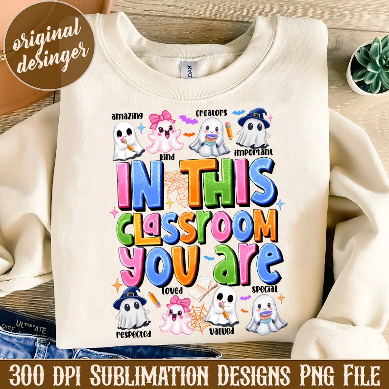 May include: A white sweatshirt with a sublimation design featuring a colorful graphic of ghosts and the text "In this classroom you are..." with words like "amazing", "kind", "important", "loved", "respected", "valued", and "special" surrounding the ghosts.