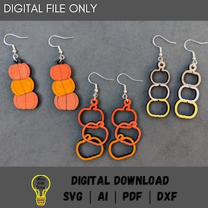 May include: Three pairs of pumpkin-shaped earrings. The first pair is stacked with three pumpkins in orange, yellow, and red. The second pair is stacked with three pumpkins in orange, yellow, and red. The third pair is stacked with three pumpkins in yellow, white, and gray.