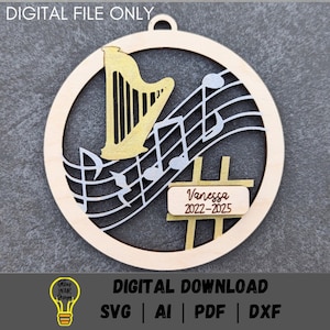 May include: A round wooden ornament with a gold harp and musical notes. The ornament has a personalized name tag with the text "Vanessa 2022-2025".