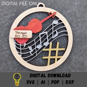 May include: A wooden circle ornament with a cutout design of a violin and musical notes. The ornament is painted in shades of red, yellow, and white. The text "Vanessa 2022-2025" is on a small rectangular tag.