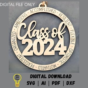 May include: A wooden circle ornament with the text "Class of 2024" in the center. The circle is surrounded by the words "Ambitious - Accomplished - Resilient - Flexible - Optimistic - Motivated - Persistent - Organized".