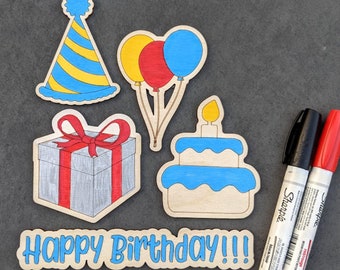 May include: A set of five wooden cutouts for a birthday party. The cutouts are in the shape of a birthday hat, balloons, a present, a cake, and the words "Happy Birthday!!!".