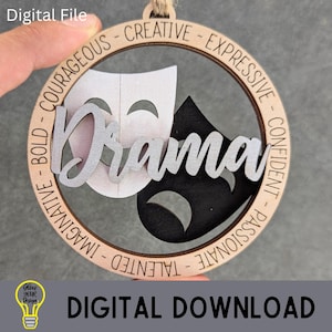 May include: A wooden ornament with the word "Drama" in silver script, featuring a white and black theater mask design. The ornament is circular, with words like "Courageous" and "Creative" around the edge. The words "Digital File" and "Digital Download" are also present.