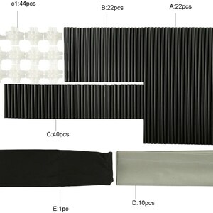 Puede incluir: Un conjunto de piezas de pl&aacute;stico blanco y negro para construir un sistema de almacenamiento modular. El conjunto incluye 44 piezas de conexi&oacute;n blancas, 40 varillas negras y 22 varillas negras de dos longitudes diferentes. El conjunto tambi&eacute;n incluye una bolsa de almacenamiento de tela negra y una bolsa de almacenamiento de tela gris.