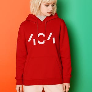 May include: A red hoodie with the text "404" in white. The hoodie has a front pocket and a hood. The model is wearing a grey turtleneck underneath. The background is split between orange and green.