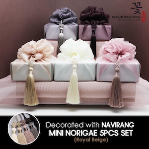 May include: Set of five mini Korean traditional gift boxes with decorative fabric tops and tassels. The boxes are in various colors, including beige, pink, and white. The boxes are decorated with the text "Decorated with NAVIRANG MINI NORIGAE 5PCS SET (Royal Beige)".