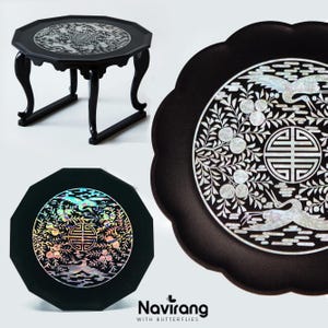 May include: Black octagonal side table with curved legs and a decorative inlaid top. The top features a detailed design with a central emblem and surrounding floral and bird motifs. The table is a traditional Asian-inspired piece.